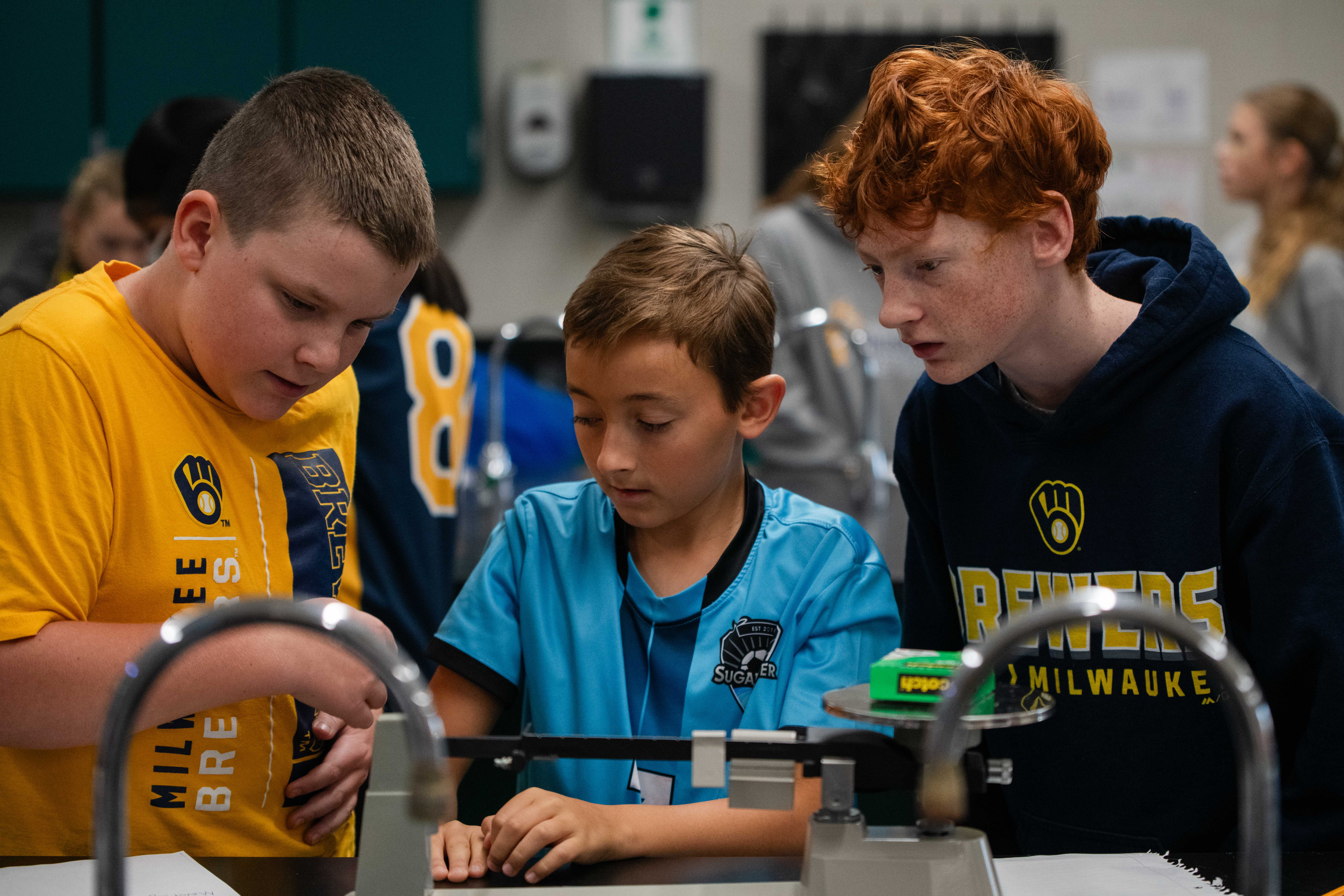 3 MS students doing a science lab experiment